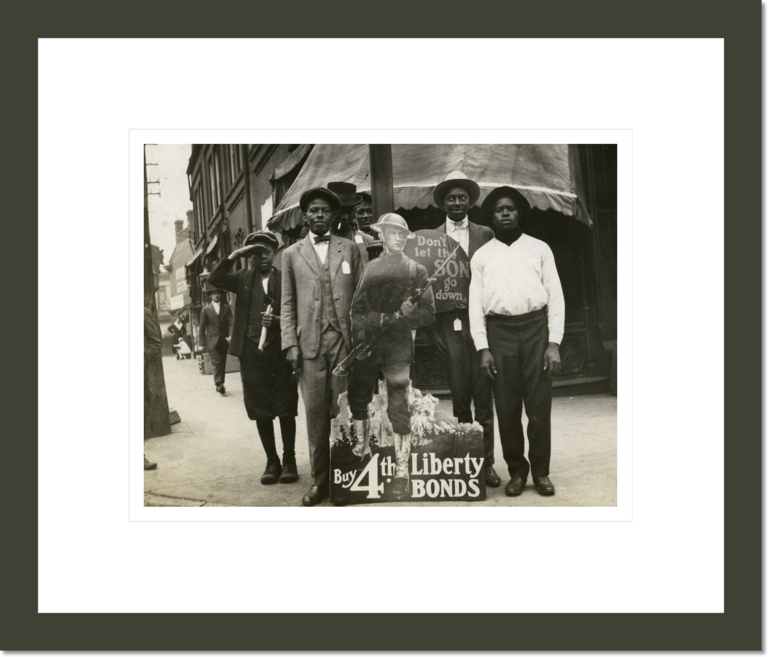 African American men and boys with Fourth Liberty Loan sign at the corner of Jefferson and Market Streets