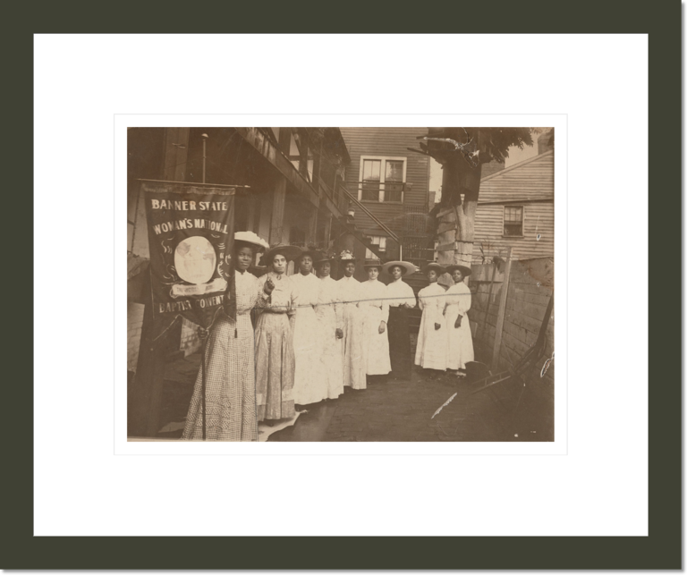 [Nine African-American women posed, standing, full length, with Nannie Burroughs holding banner reading, 